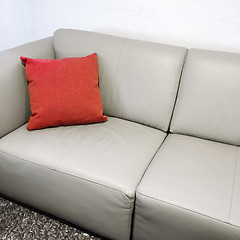 Image showing Simple leather sofa with red cushion