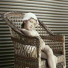 Image showing Beautiful small girl seating in wicker chair