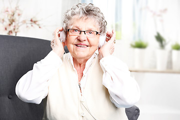 Image showing Grandma listens to music. A moment of relaxation, rest grandmother listening to music.
