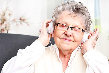 Image showing Grandma listens to music. A moment of relaxation, rest grandmother listening to music.