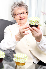 Image showing Grandma prepares komfitury in jars. Grandma's preserves, delicious jams.