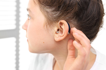 Image showing A child with a hearing aid. The girl assumes hearing aid. Hearing aid for your child 