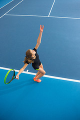 Image showing The young girl in a closed tennis court with ball