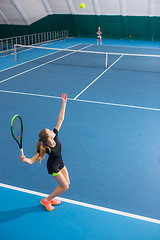 Image showing The young girl in a closed tennis court with ball