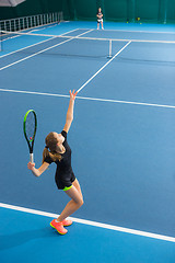 Image showing The young girl in a closed tennis court with ball
