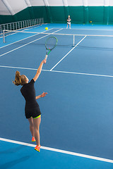 Image showing The young girl in a closed tennis court with ball