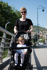 Image showing mother pushed her baby daughter in a stroller