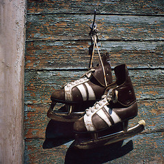 Image showing vintage pair of mens  ice skates hanging on a wall