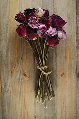 Image showing bouquet of dried roses on a wooden background