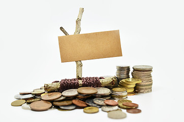 Image showing Paper sign board with stack of coins