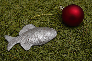 Image showing Christmas ball and fish on green fur-tree needles