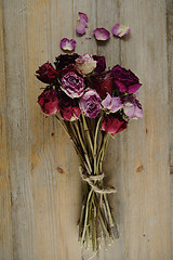 Image showing bouquet of dried roses on a wooden