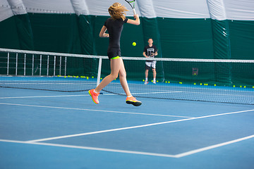 Image showing The young girl in a closed tennis court with ball