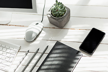 Image showing Office desk table with computer, supplies and phone