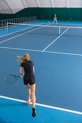 Image showing The young girl in a closed tennis court with ball