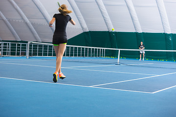 Image showing The young girl in a closed tennis court with ball