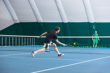 Image showing The young man in a closed tennis court with ball