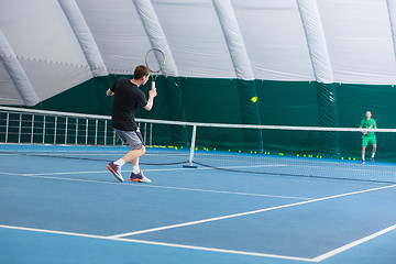 Image showing The young man in a closed tennis court with ball