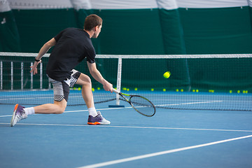 Image showing The young man in a closed tennis court with ball