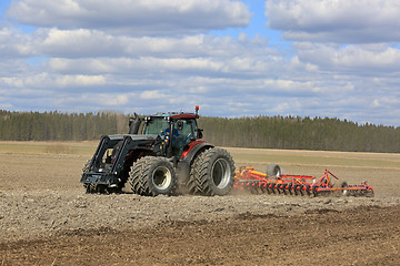 Image showing Valtra Tractor and Cultivator on Field at Spring