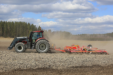 Image showing Farm Tractor and Cultivator on Spring Field