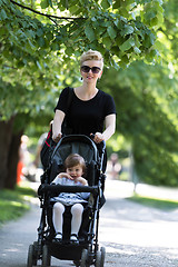 Image showing mother pushed her baby daughter in a stroller