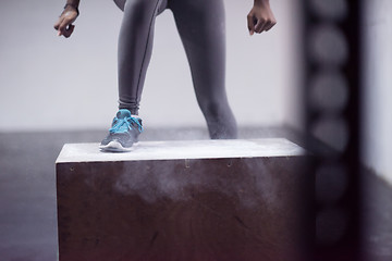 Image showing black woman is performing box jumps at gym