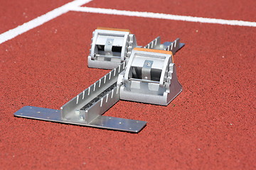 Image showing Athletics starting blocks on race red track