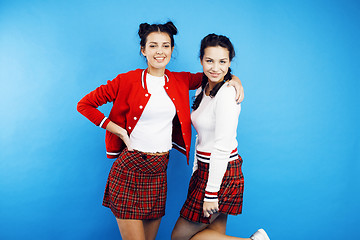 Image showing best friends teenage school girls together having fun, posing emotional on blue background, besties happy smiling, lifestyle people concept 