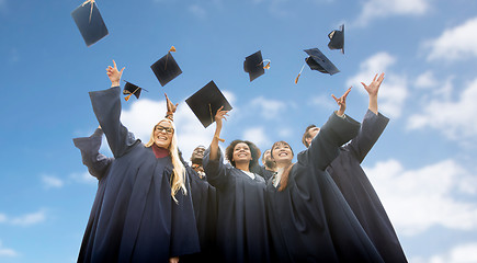 Image showing happy students throwing mortar boards up