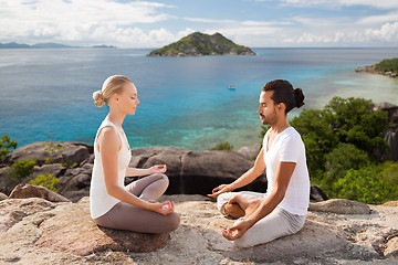 Image showing happy couple doing yoga and meditating outdoors