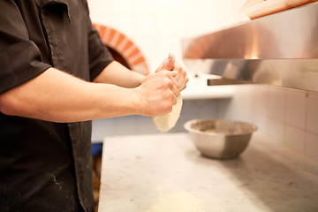 Image showing chef hands preparing dough on table at kitchen