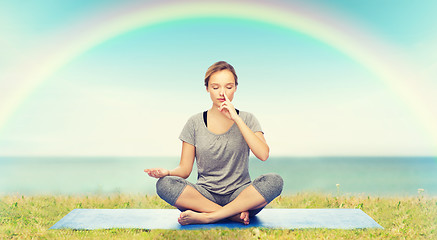 Image showing woman making yoga meditation in lotus pose on mat