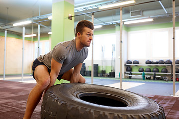 Image showing man doing strongman tire flip training in gym
