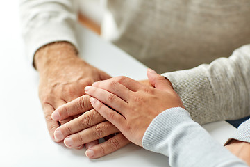 Image showing close up of old man and young woman holding hands