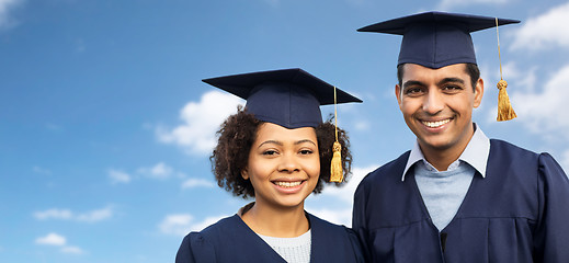 Image showing students or bachelors in mortar boards over sky
