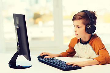 Image showing boy with computer and headphones at home