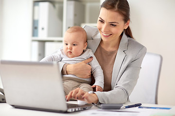 Image showing happy businesswoman with baby and laptop at office