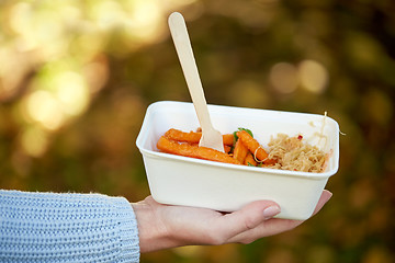 Image showing close up of hand holding plate with sweet potato