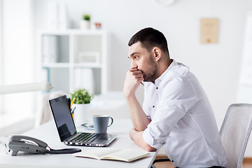 Image showing businessman with laptop and notebook at office