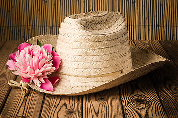 Image showing Straw hat and peony flower, close-up