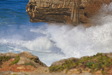 Image showing Marine wave breaks against offshore stone