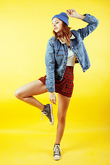 Image showing young pretty teenage girl emotional posing on yellow background, fashion lifestyle people concept