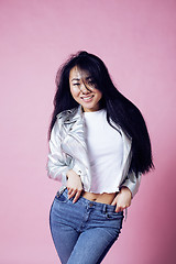 Image showing young pretty smiling asian korean girl wearing modern fashion clothers on pink background, lifestyle people concept 