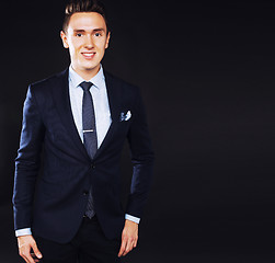 Image showing young pretty business man standing on black background, modern h