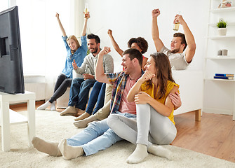 Image showing happy friends with beer watching tv at home