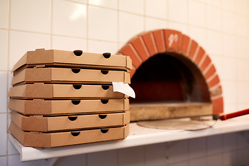 Image showing close up of pizza in box on table at pizzeria oven