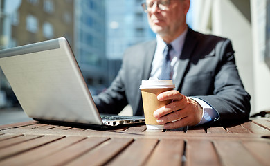 Image showing senior businessman with laptop and coffee outdoors