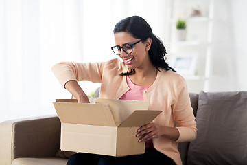 Image showing happy young indian woman with parcel box at home