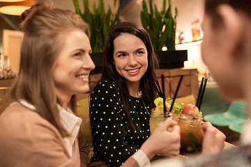 Image showing happy friends clinking drinks at restaurant